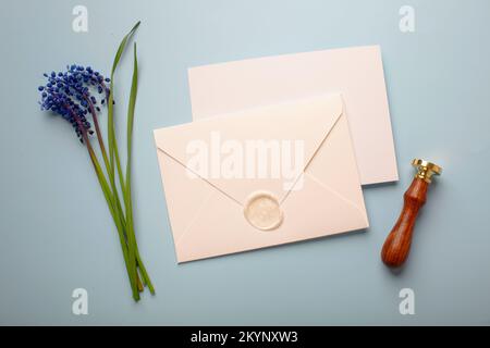 fiori blu con una busta bianca sul tavolo. Foto di alta qualità Foto Stock