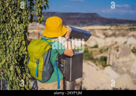 Ragazzo turistico esplorando la valle con formazioni rocciose e grotte delle fate vicino a Goreme in Cappadocia Turchia Foto Stock