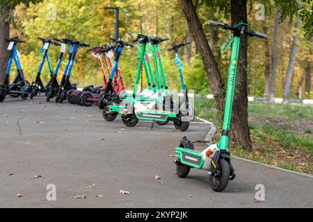 Kharkiv, Ucraina - 5 ottobre 2021: Scooter elettrici parcheggio nelle strade della città. Scooter elettrico pubblico con sfondo sfocato, trasporto ecologico Foto Stock