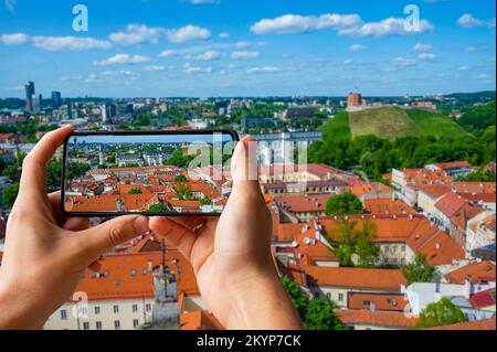 Turista fotografare la città vecchia di Vilnius in Lituania. Vista di St. Cattedrale di Stanislao in Piazza della Cattedrale, Gediminas castello sulla collina Foto Stock