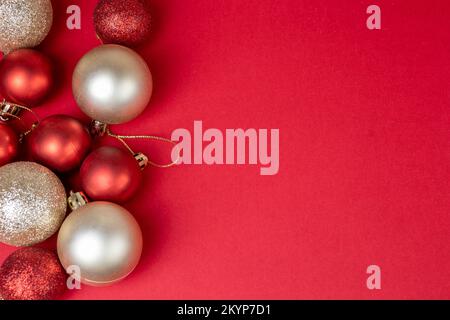 Palline di natale rosse e dorate su sfondo rosso con vista dall'alto dello spazio copia, modello per cartoline, banner. Foto Stock