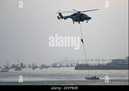 Mumbai, India. 01st Dec, 2022. Il personale della Marina Indiana esegue acrobazie utilizzando una corda mentre sale verso l'Advance Light Helicopter (ALH) da una barca vicino al Gateway of India a Mumbai. La cerimonia del ritiro e del tatuaggio battendo dalla Marina indiana viene eseguita come parte della celebrazione della settimana della Marina a Mumbai. (Foto di Ashish Vaishnav/SOPA Images/Sipa USA) Credit: Sipa USA/Alamy Live News Foto Stock