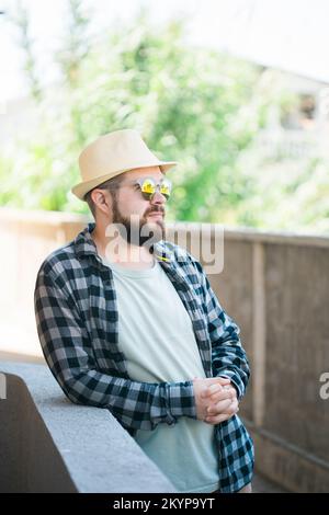 Uomo ritratto in abiti estivi e cappello stand sulla strada città urbano e concetto di viaggio Foto Stock