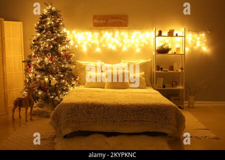 Interno della camera da letto con albero di Natale, scaffale e luci di notte  Foto stock - Alamy