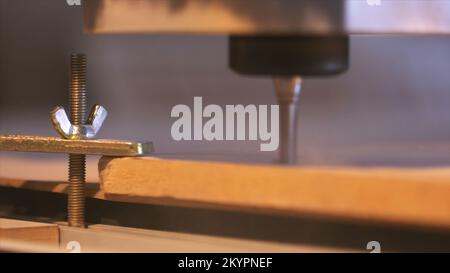 Primo piano della macchina per il taglio del legno controllata da un computer mentre intagliava il legno. Fresa CNC per la lavorazione di una parte in legno. Foto Stock