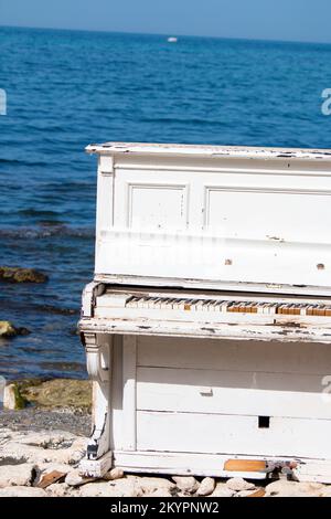 Un vecchio piano bianco sulla spiaggia, un vecchio pianoforte bianco sulla spiaggia Foto Stock