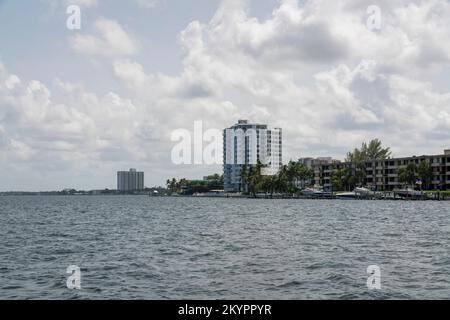 Baia di Miami in Florida skyline nuvoloso sopra gli appartamenti e condomini. C'e' una vista dell'acqua sul fronte e degli yacht sul davanti del bu Foto Stock