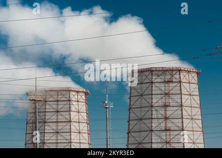 Il fumo tossico viene rilasciato dalla torre di raffreddamento nell'atmosfera e inquina l'ambiente, l'aria e l'atmosfera. Funzionamento del calore industriale Foto Stock