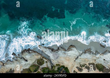 Volo sopra le onde turchesi dell'oceano, vista dall'alto verso il basso Foto Stock