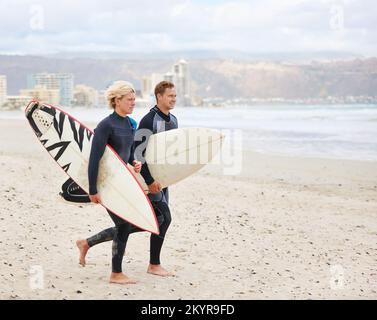 Il surf non è più rinvigorente. I giovani surfisti sono entusiasti di colpire le onde impressionanti. Foto Stock