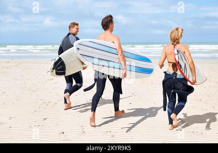 Il surf non è più rinvigorente. I giovani surfisti sono entusiasti di colpire le onde impressionanti. Foto Stock