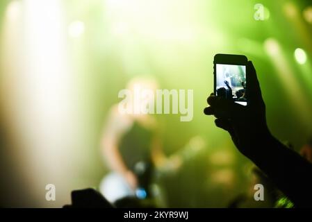 Cattura l'attimo. Una persona che filma la propria band preferita con un telefono con fotocamera. Foto Stock