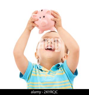 HES sarà ricco un giorno. Foto studio di un giovane ragazzo che sorregge una banca di piggy isolato su bianco. Foto Stock