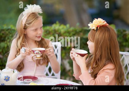 Una festa del tè fai-da-te. Due ragazze giovani che hanno un partito del tè nel cortile posteriore. Foto Stock