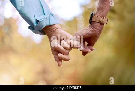 Pensione, coppia anziana e mani in mano per amore, romanticismo e legame insieme. Romantico, gesto della mano e amore per il rapporto, il matrimonio e. Foto Stock