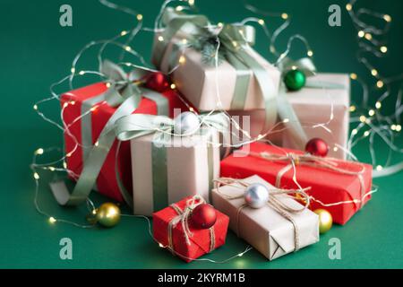 Regalo di Natale e decorazioni su sfondo verde. Foto Stock