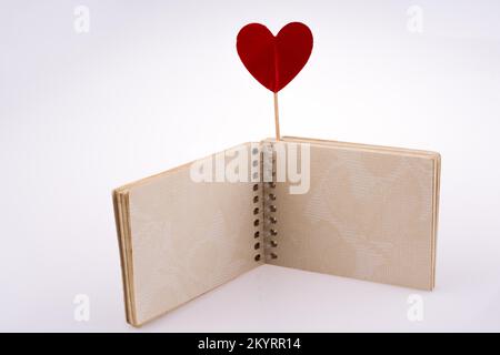 Cuore rosso stick su un notebook Foto Stock