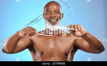 Spazzolino da denti, bambù e uomo nero in studio con dentifricio, spruzzi d'acqua e ritratto per dentale, bocca e promozione prodotti in legno. Faccia del modello senior Foto Stock