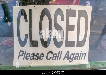 San Antonio, California - Segnaletica con chiuso si prega di chiamare di nuovo. Messa a fuoco selettiva della segnaletica dietro la parete di vetro con riflesso all'aperto. Foto Stock