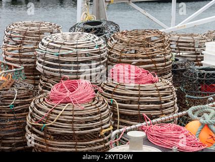 Pentole di aragosta impilate sul ponte di un peschereccio in attesa di essere posate in mare. Foto Stock