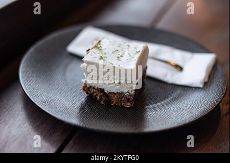La ragazza mangia un dessert vegano crudo con tè nel caffè Foto Stock