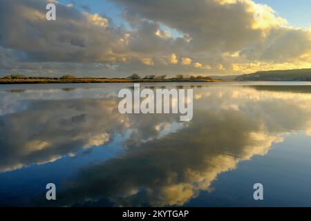 Nel tardo pomeriggio sole invernale e nuvole sopra le acque cristalline di Slapton Ley, Start Bay, South Devon, UK Foto Stock