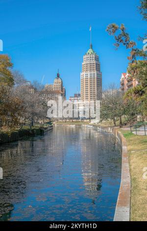 Vista sul fiume San Antonio e su un'alta torre a San Antonio, passeggiata sul fiume Texas. Vecchio edificio torre contro il cielo vicino al San Antonio River Walk. Foto Stock