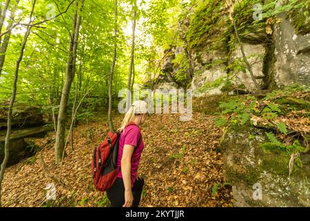 donna scogliera in montagna, donna con zaino in montagna Foto Stock