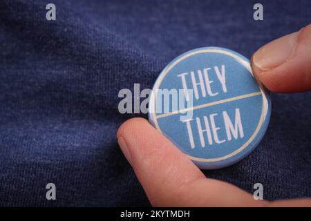 Una persona che mostra loro pronouns indossando un distintivo. Foto Stock