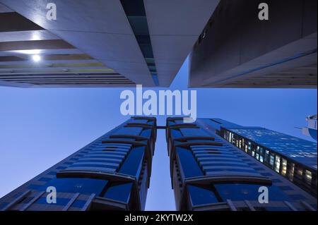 Dubai, Emirati Arabi Uniti - vista ad angolo basso di edifici alti e moderni di notte. Grattacieli della città dal basso. Centro città al crepuscolo. Foto Stock