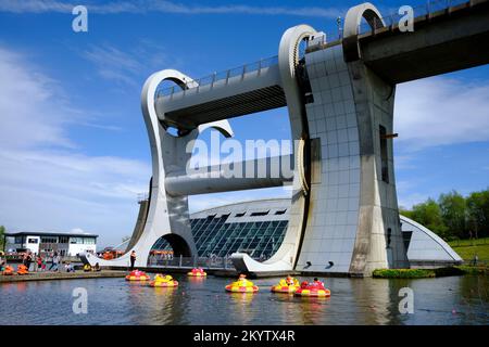 La Falkirk Wheel motoscafo in una giornata di sole con i bambini che galleggiano in gommoni in primo piano Foto Stock