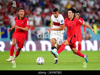 Le Matheus Nunes (al centro) del Portogallo e la Hwang in-beom della Corea del Sud combattono per la palla durante la partita del Gruppo H della Coppa del mondo FIFA presso l'Education City Stadium di al-Rayyan, Qatar. Data immagine: Venerdì 2 dicembre 2022. Foto Stock