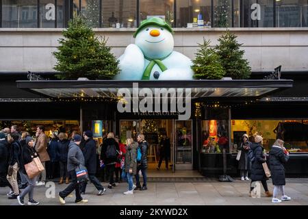 Londra, Regno Unito. 2 dicembre 2022. La gente passa la libreria Waterstones a Piccadilly il cui esterno è stato decorato per Natale con il personaggio Snowman del libro dell'autore britannico Raymond Briggs. Raymond Briggs morì nell'agosto di quest'anno all'età di 88 anni. Credit: Stephen Chung / Alamy Live News Foto Stock