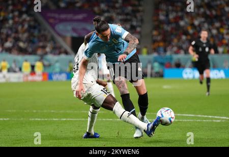 Daniel Amartey (a sinistra) del Ghana abbatte il Nunez Darwin dell'Uruguay, che dopo una revisione del VAR non viene inflitta come sanzione durante la partita del Gruppo H della Coppa del mondo FIFA allo stadio al Janoub di al-Wakrah, Qatar. Data immagine: Venerdì 2 dicembre 2022. Foto Stock