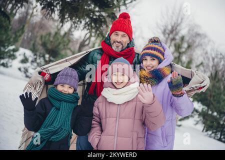 Ritratto di quattro persone allegre idilliaco coprire spalla coperta braccio palma agitare trascorrere il passatempo all'esterno Foto Stock
