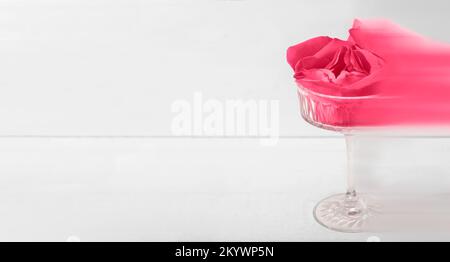 Viva magenta colore 2023. i petali di rosa in movimento si sfumano in un bicchiere. tonalità trendy in colore magenta viva di 2023 anno. spazio di copia Foto Stock