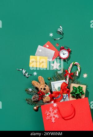 Esplosione di vacanza dalla borsa della spesa su sfondo verde. Buon Natale e felice anno nuovo concetto Foto Stock