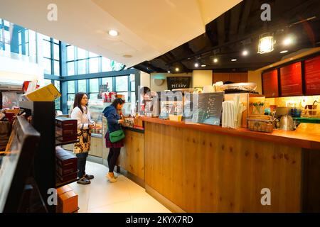 HONG KONG - 26 DICEMBRE 2015: Interno del caffè Starbucks. Starbucks Corporation è un'azienda americana globale di caffè e una catena di caffetterie con sede a S. Foto Stock