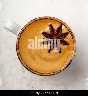 Primo piano di una tazza di caffè con anice stellato e crema esettiva Foto Stock