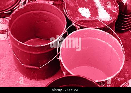 Secchio sporco di colore viva magenta su asfalto con pennello. Vecchia vernice in lattine disordinato e arrugginito pronto per il riciclaggio. Primo piano. Colore trendy degli anni '202 Foto Stock