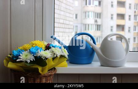 Fiori Bouquet vicino bianco e blu Long bocca annaffiatoio lattine su Un davanzale di balcone casa Foto Stock