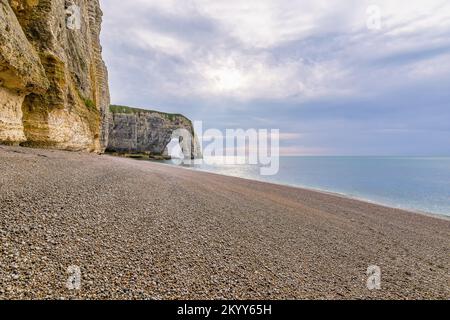 Vista panoramica delle scogliere di Etretat in Normandia Francia con spiaggia di ciottoli contro il cielo drammatico Foto Stock