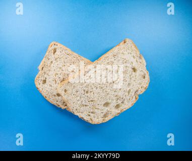 due fette di pane fresco seminato isolato su sfondo blu scuro Foto Stock