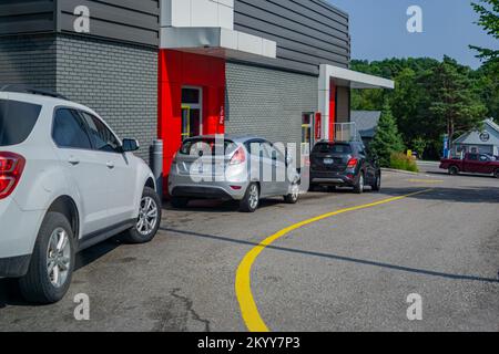 Ontario, Canada, 2021 agosto - i veicoli che allineano fuori di un azionamento del MacDonald attraverso Foto Stock