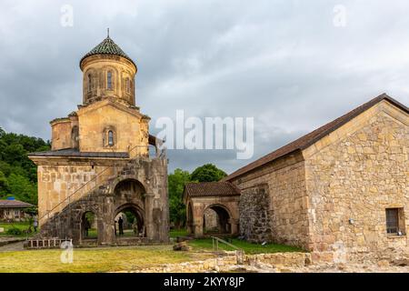 Campanile del Monastero gelati (campanile), complesso monastico medievale nei pressi di Kutaisi, Georgia fondato da re Davide IV, pareti in pietra con tetti in tegole verdi. Foto Stock