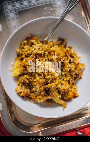 Primo piano con piatto di riso basmati persiano, Zereshk Polo ba Morgh, riso allo zafferano con barrioli e pollo Foto Stock