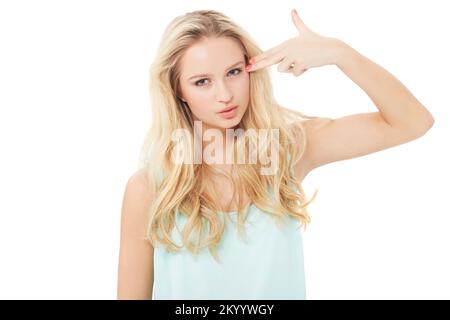 Uccidi ora, per favore. Una giovane donna graziosa che fa un gesto di pistola e che punta le dita verso la testa - isolato. Foto Stock