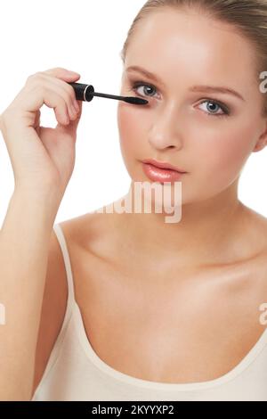 Applicazione mascara. Una giovane donna splendida applicare mascara mentre isolato su bianco. Foto Stock