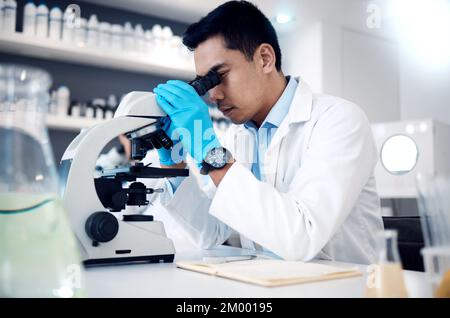 Microscopio, uomo asiatico in laboratorio per l'assistenza sanitaria, metodi scientifici e innovazione della ricerca. Ricercatore maschile, chimico e medico controllo professionale Foto Stock