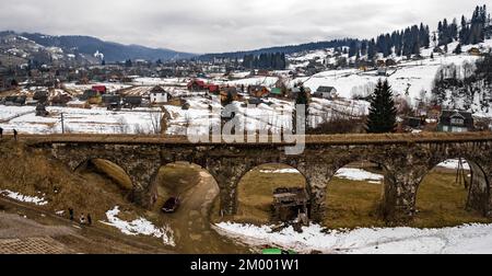 Vorokhta, Ucraina 31 marzo 2021: Tiro vicino al vecchio ponte viadotto, il ponte sullo sfondo di terreno innevato. Foto Stock